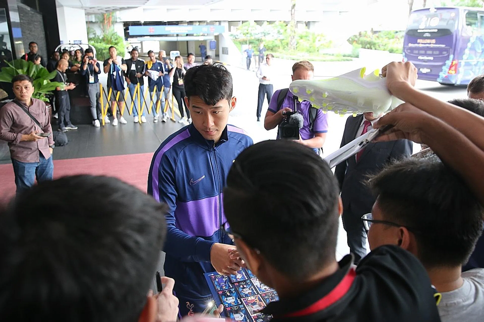 Spurs forward Son Heung Min obliging fans with autographs. 