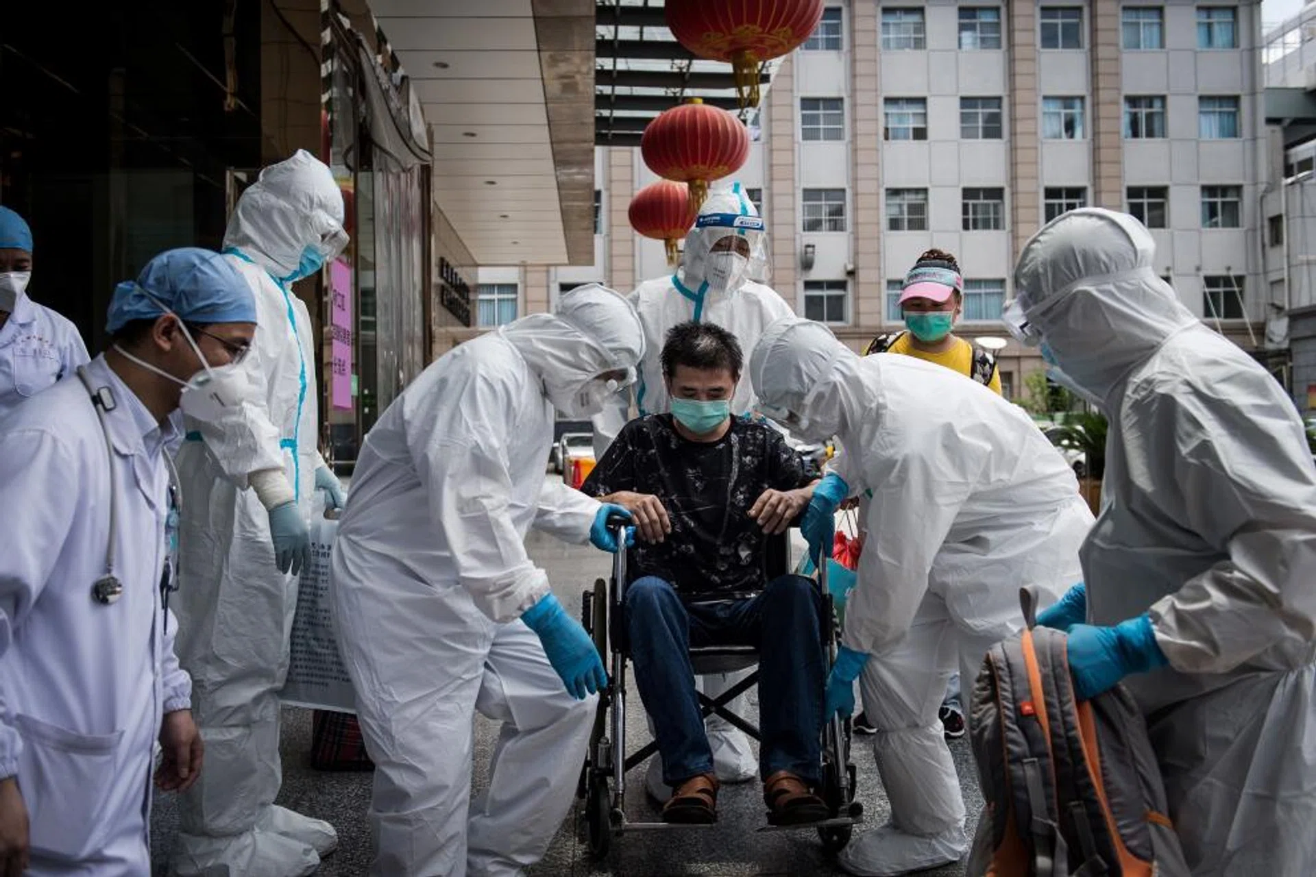 This photo taken on June 17, 2020 shows medical workers carrying a man who is the last patient recovered from the COVID-19 coronavirus infection in the Wuhan, pulmonary hospital before he leaves the hospital in Wuhan, in China's central Hubei province.