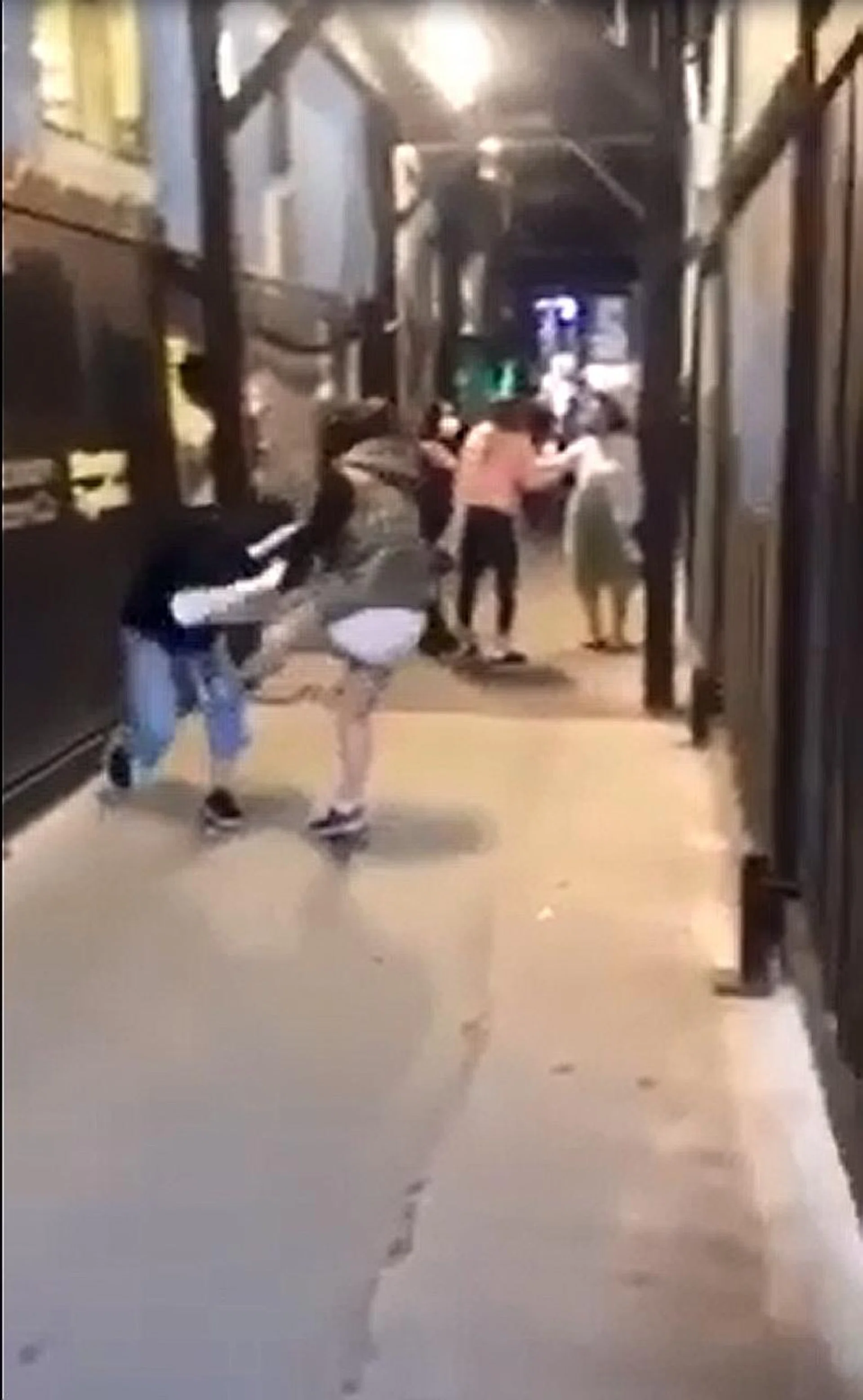 In a 20-second video, a woman in a sleeveless parka and white skirt grabs one student by the hair and punches her repeatedly on the head before dragging her to the ground and kicking her. 
