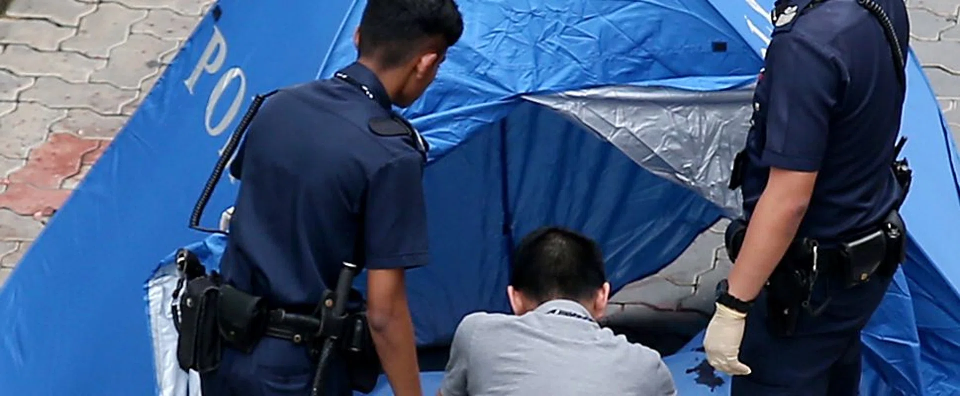 DIED: Policemen at the scene where Benjamin Lim fell out of his Yishun flat. 