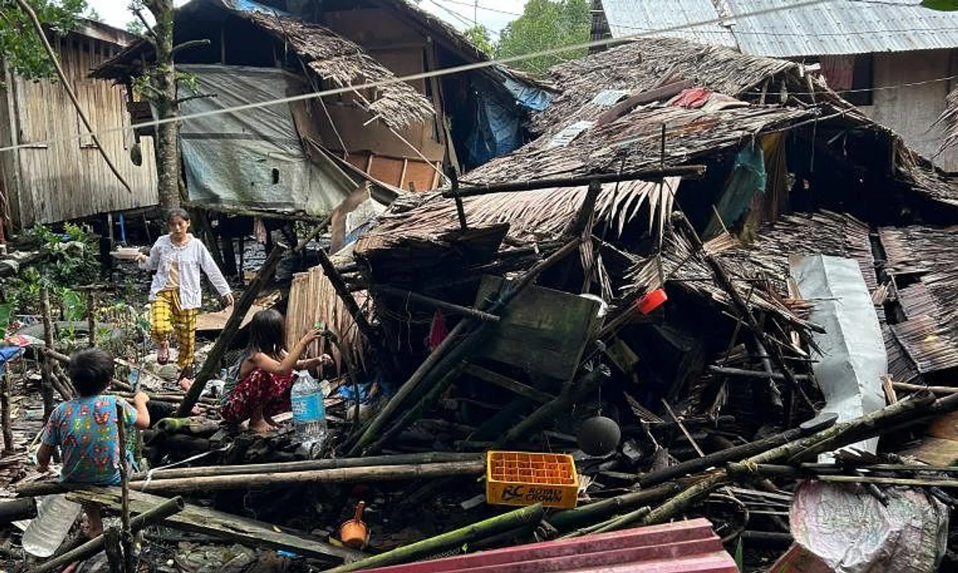 Residents fetch water next to a destroyed house in Hinatuan, Surigao del Sur province.