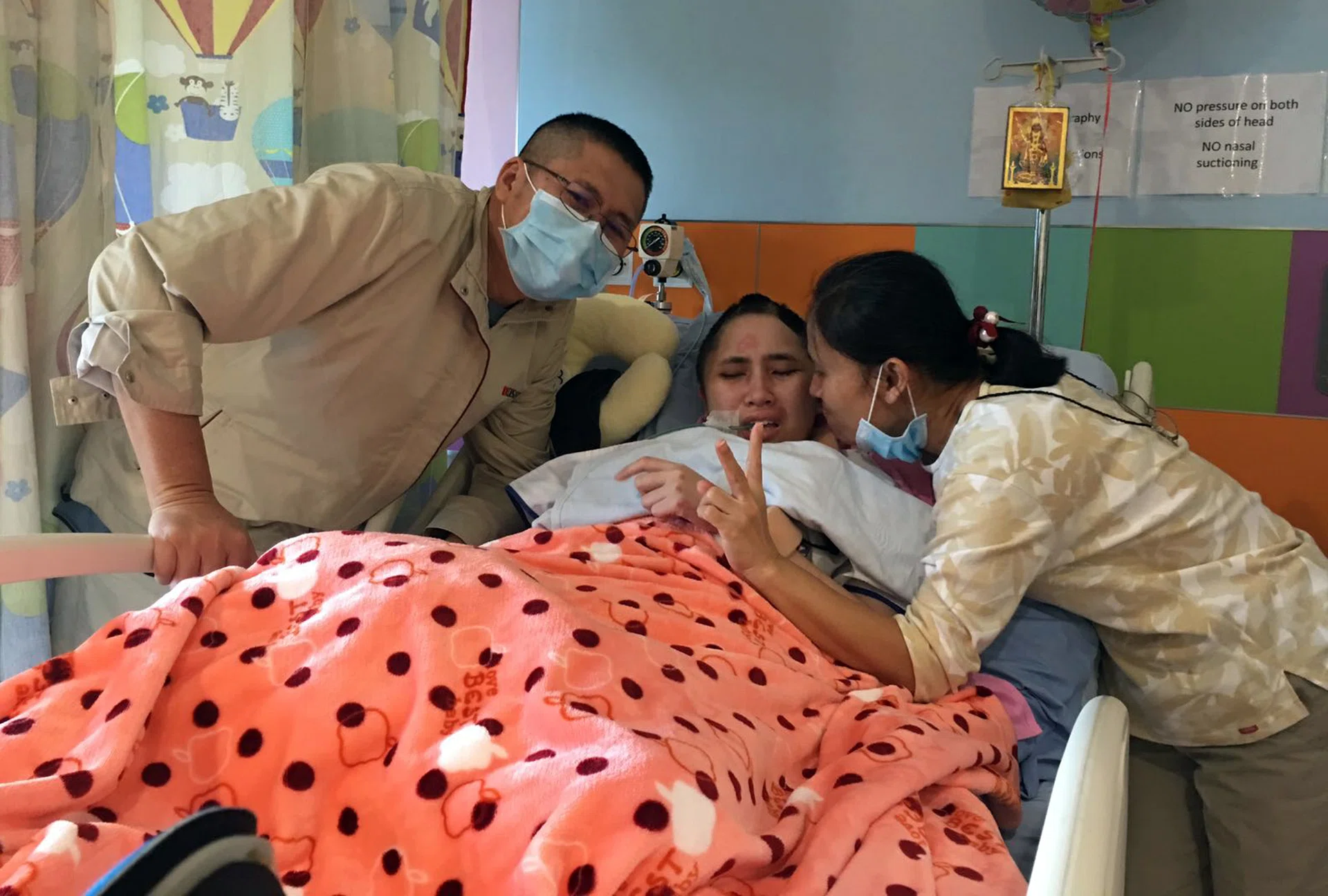 BETTER: Aroonrak (centre) with her parents. 