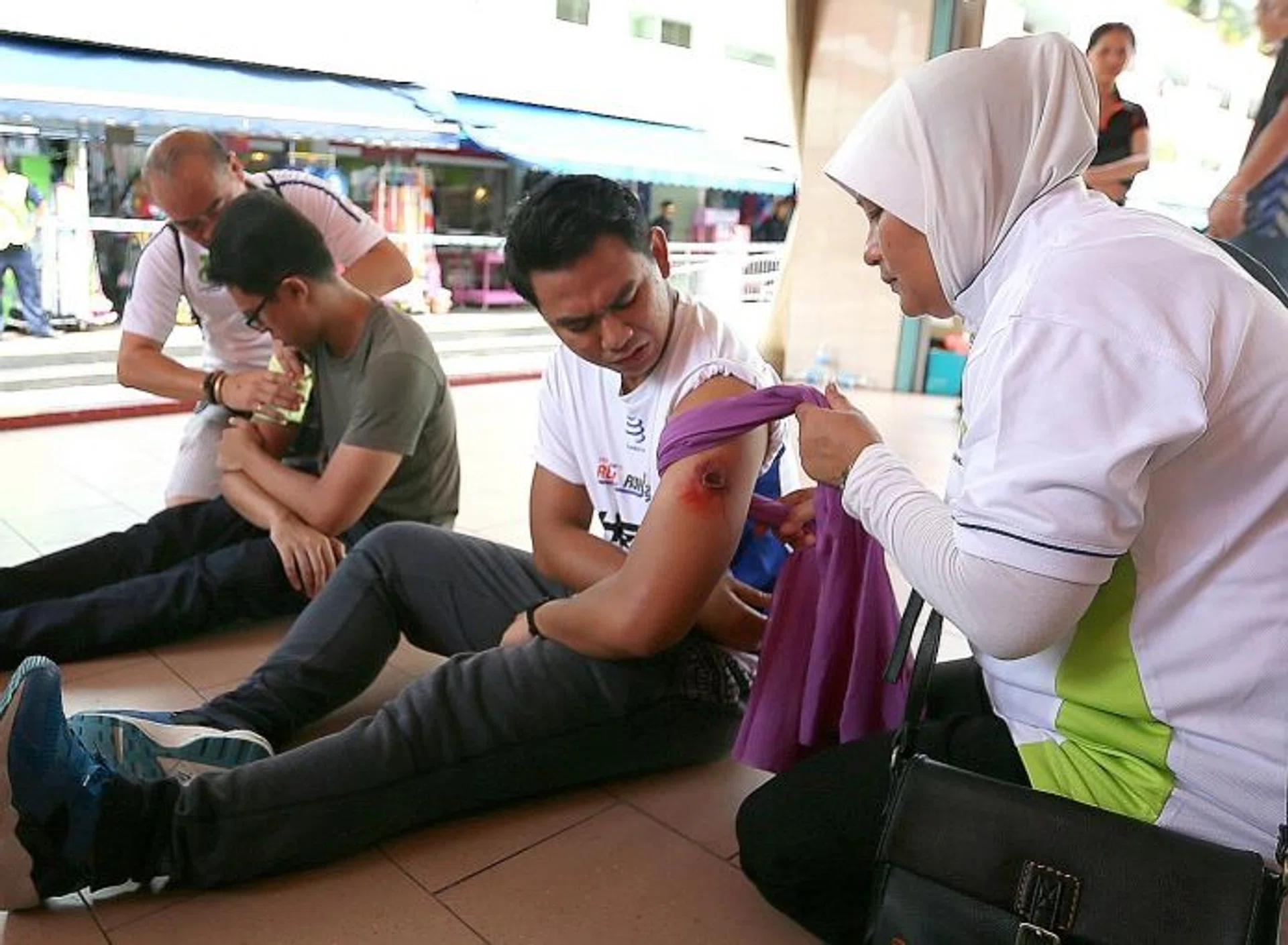 HELP: Trained individuals applying improvised first aid on wounded casualties during an exercise. 