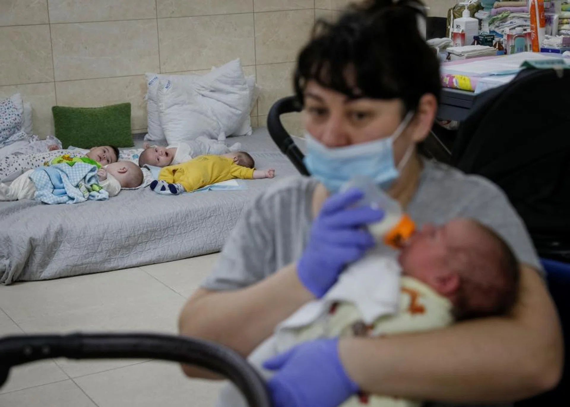 Nurse Oksana Martynenko looks after surrogate-born babies inside a special shelter in a residential basement.