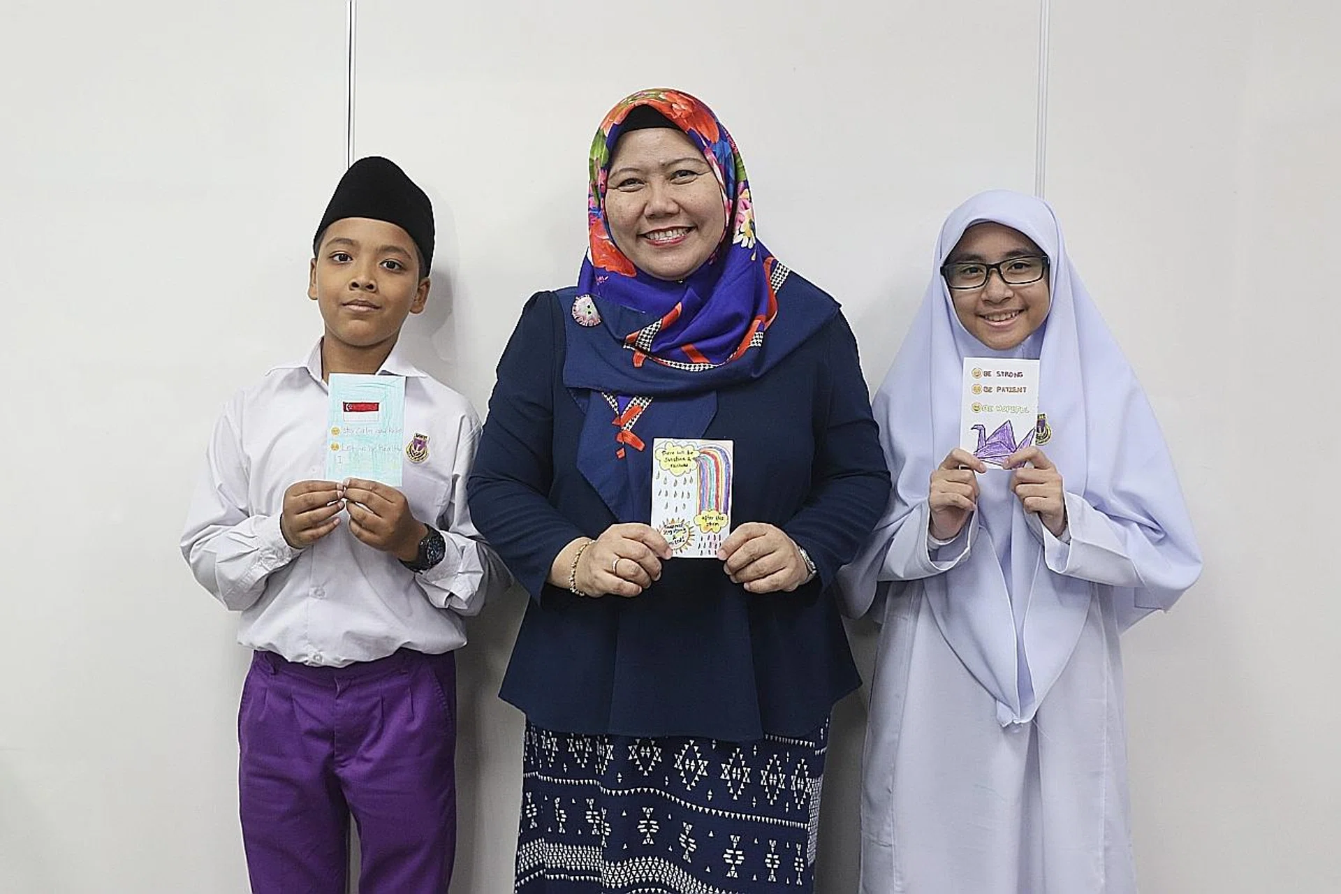 Madam Rahimah Rahim, who heads The Get Well Card Project, posing with Madrasah Wak Tanjong Al-Islamiah pupils. 