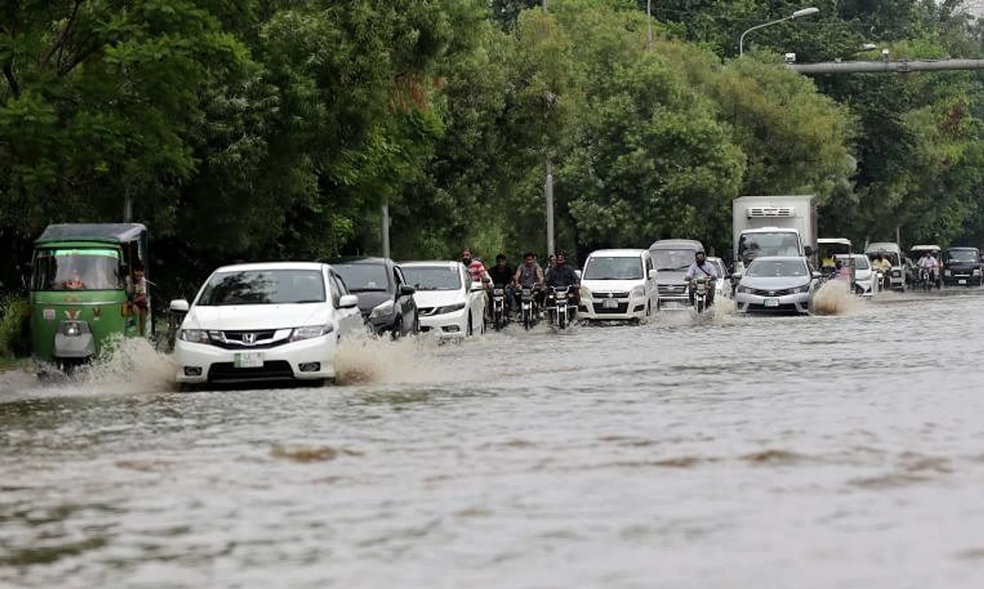 Vehicles driving through a flooded area following heavy rains in Lahore, Pakistan, on July 5.