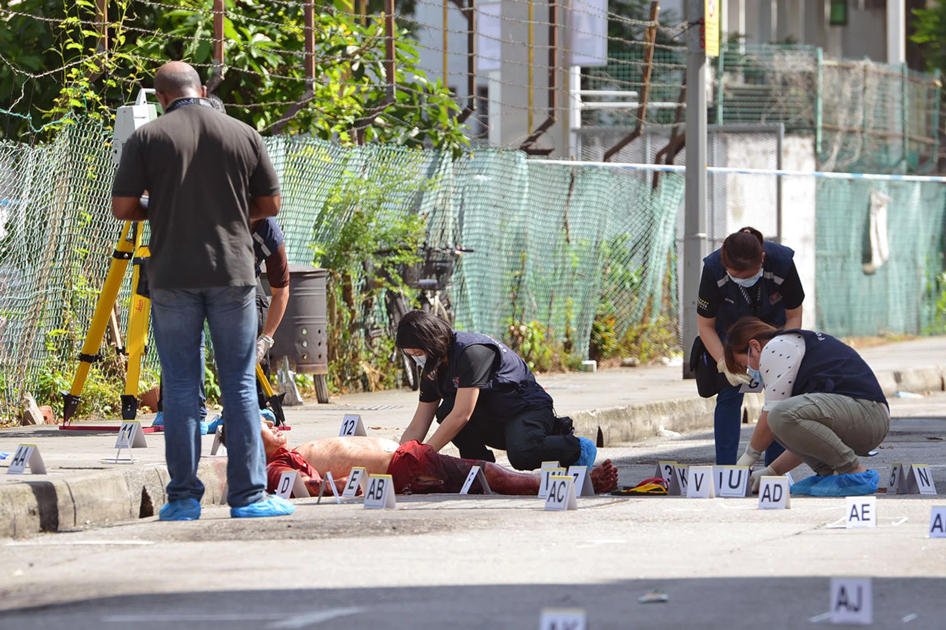(Above) Police officers investigating the scene where Mr Goh Eng Thiam was found dead at the roadside along Lorong 23 Geylang in 2016.