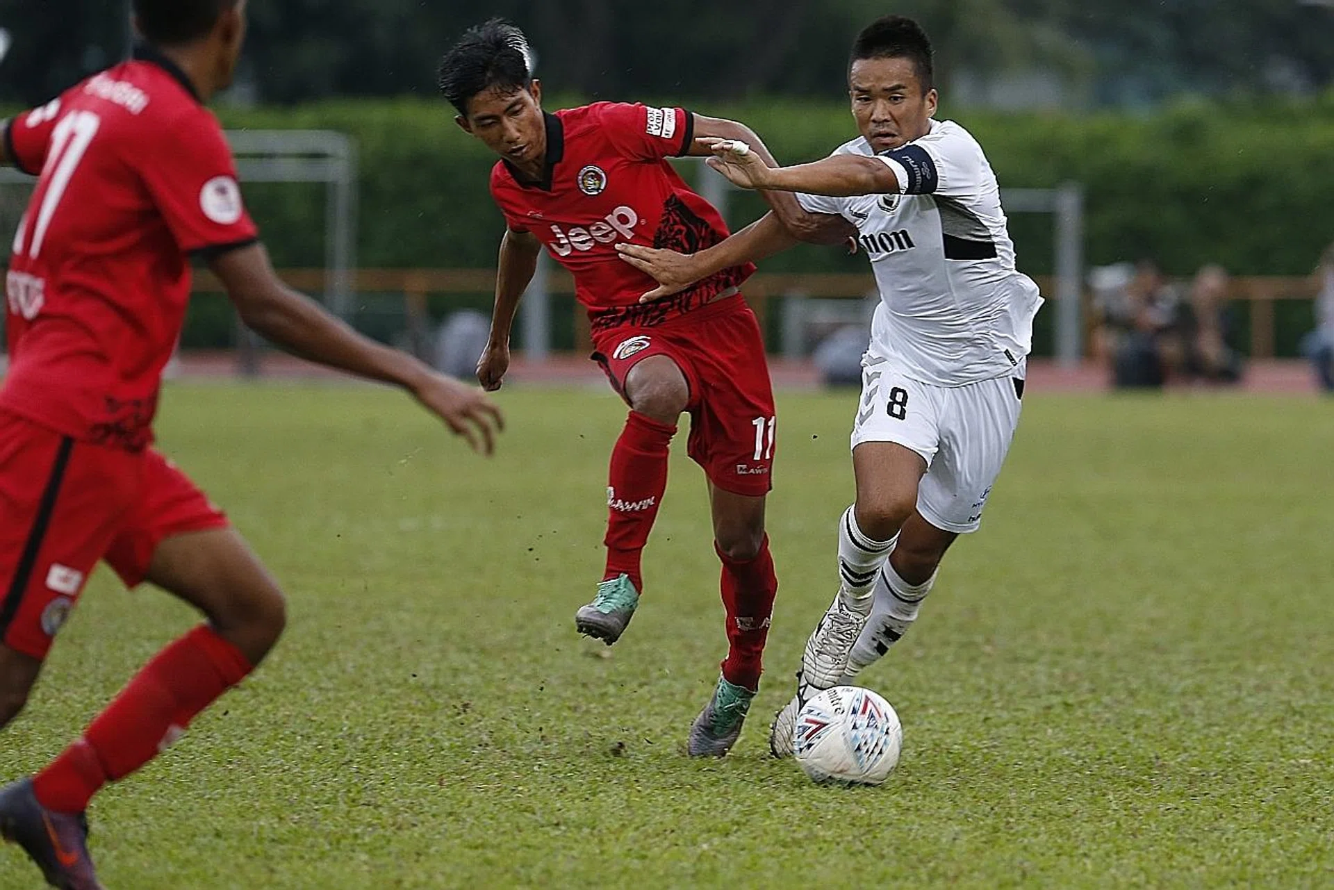 Balestier Khalsa's Huzaifah Aziz (left) tackling Albirex Niigata's Wataru Murofushi (right).