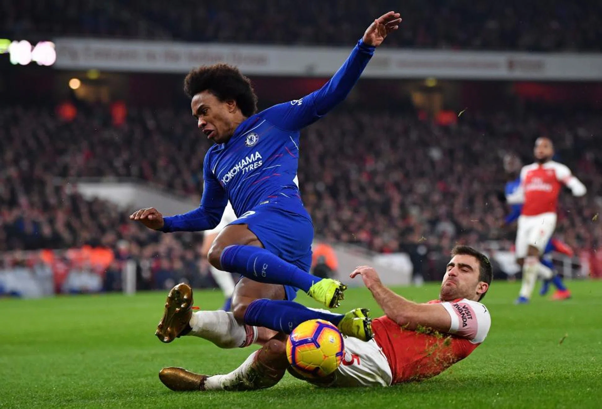 Arsenal's Sead Kolasinac tackling Chelsea forward Willian.