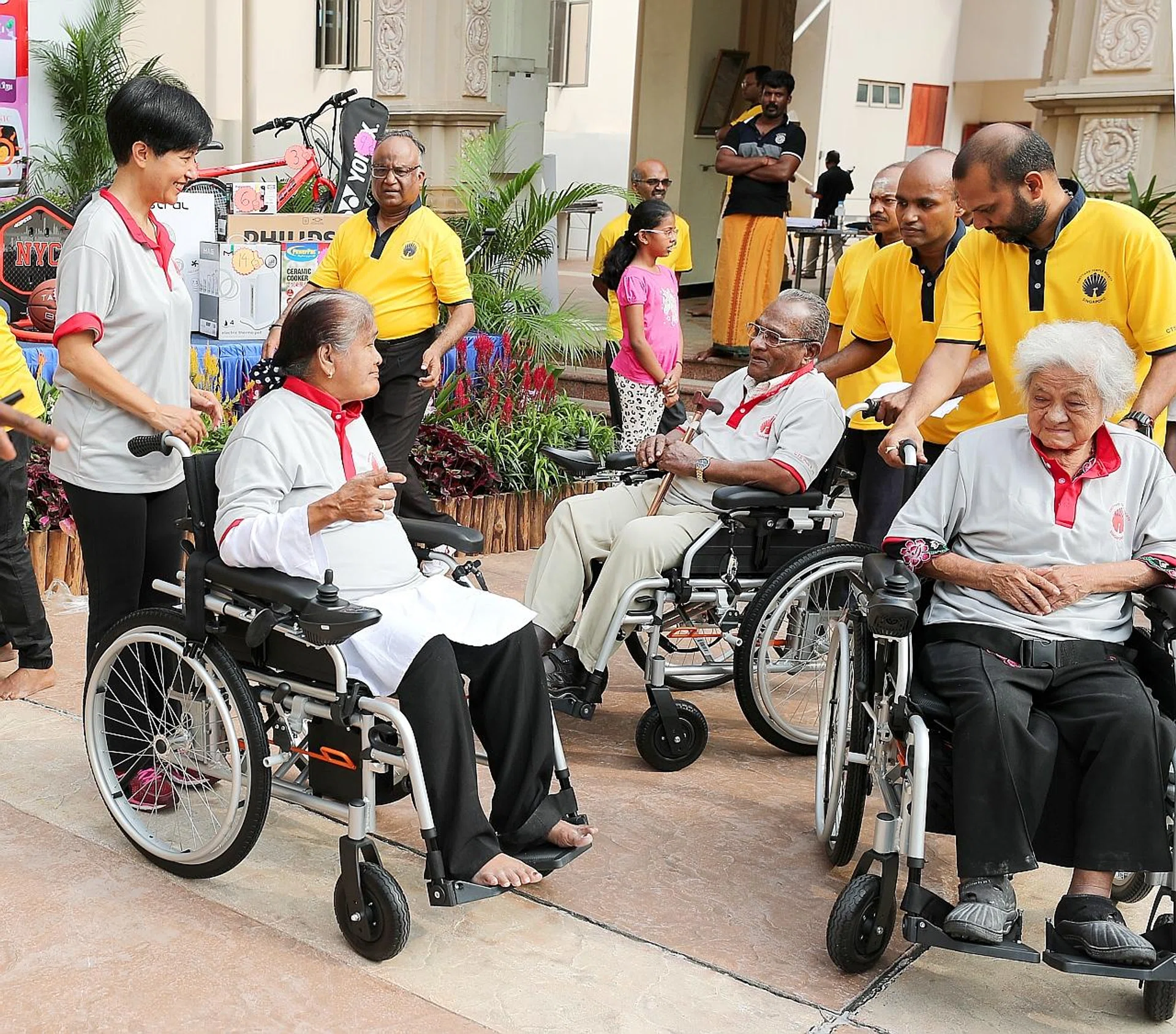 Minister in the Prime Minister's Office Indranee Rajah (far left) with some of the seniors who got a motorised wheelchair. 