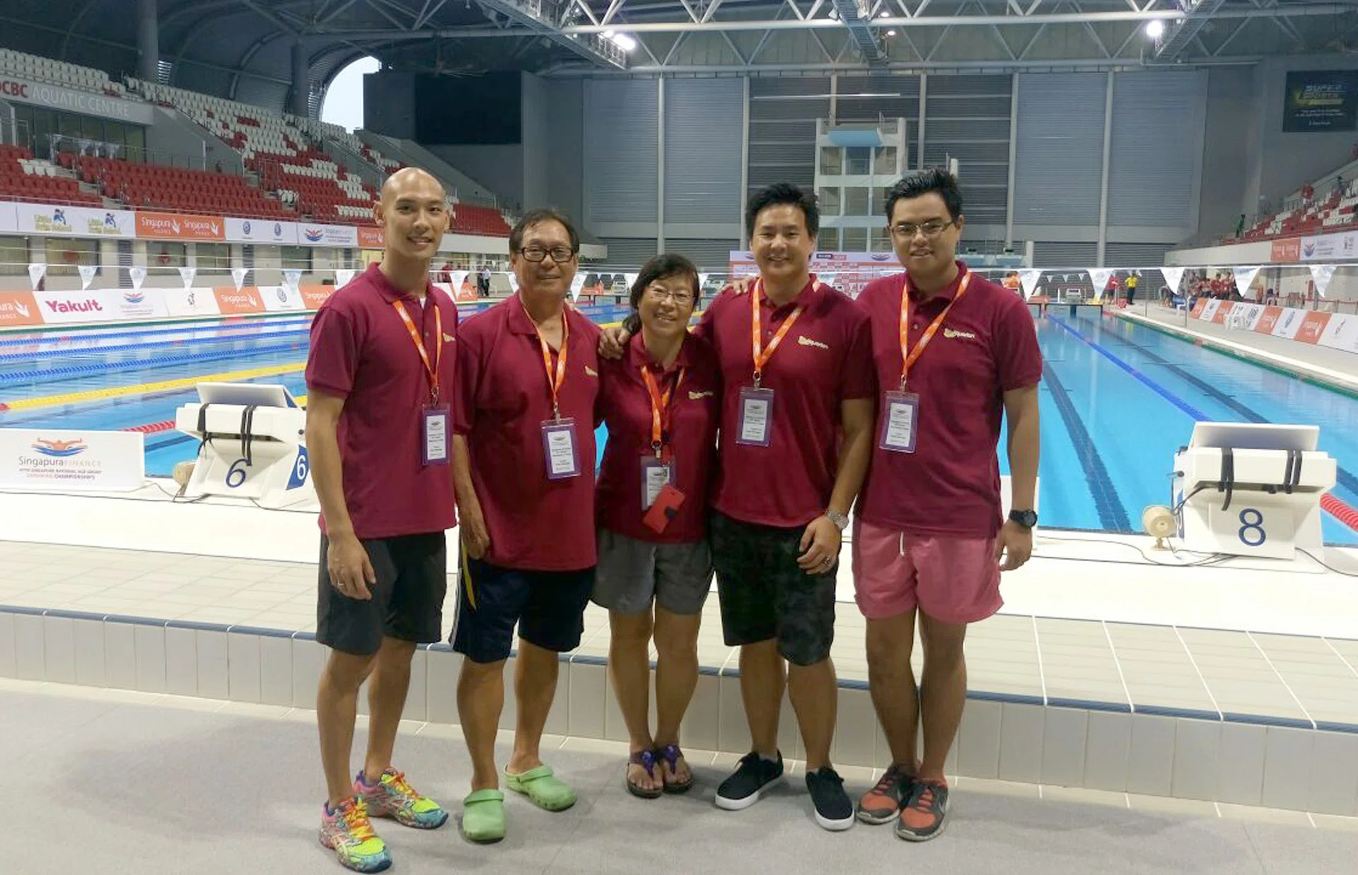 THE COACHES: Elsie Chiang (centre), along with Mark Chay (second from right) and some of the Aquarian Aquatic Swim School coaches at the end of the Singapore National Age- Group (Junior) Swimming Championships at the OCBC Aquatic Centre yesterday. 