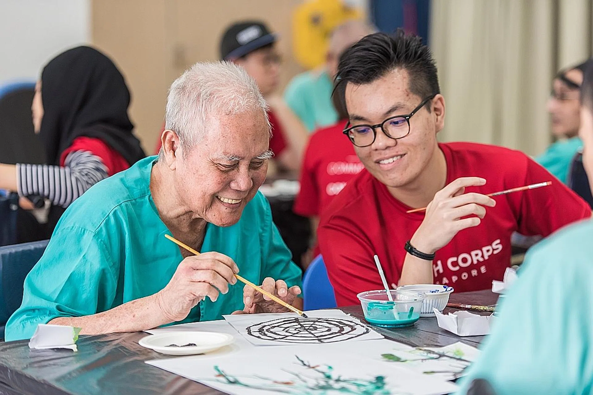 Yolden (Arts) Programme volunteer Muhammed Aqil Idrus (right) and Mr Sulaiman Mohammed painting together. 