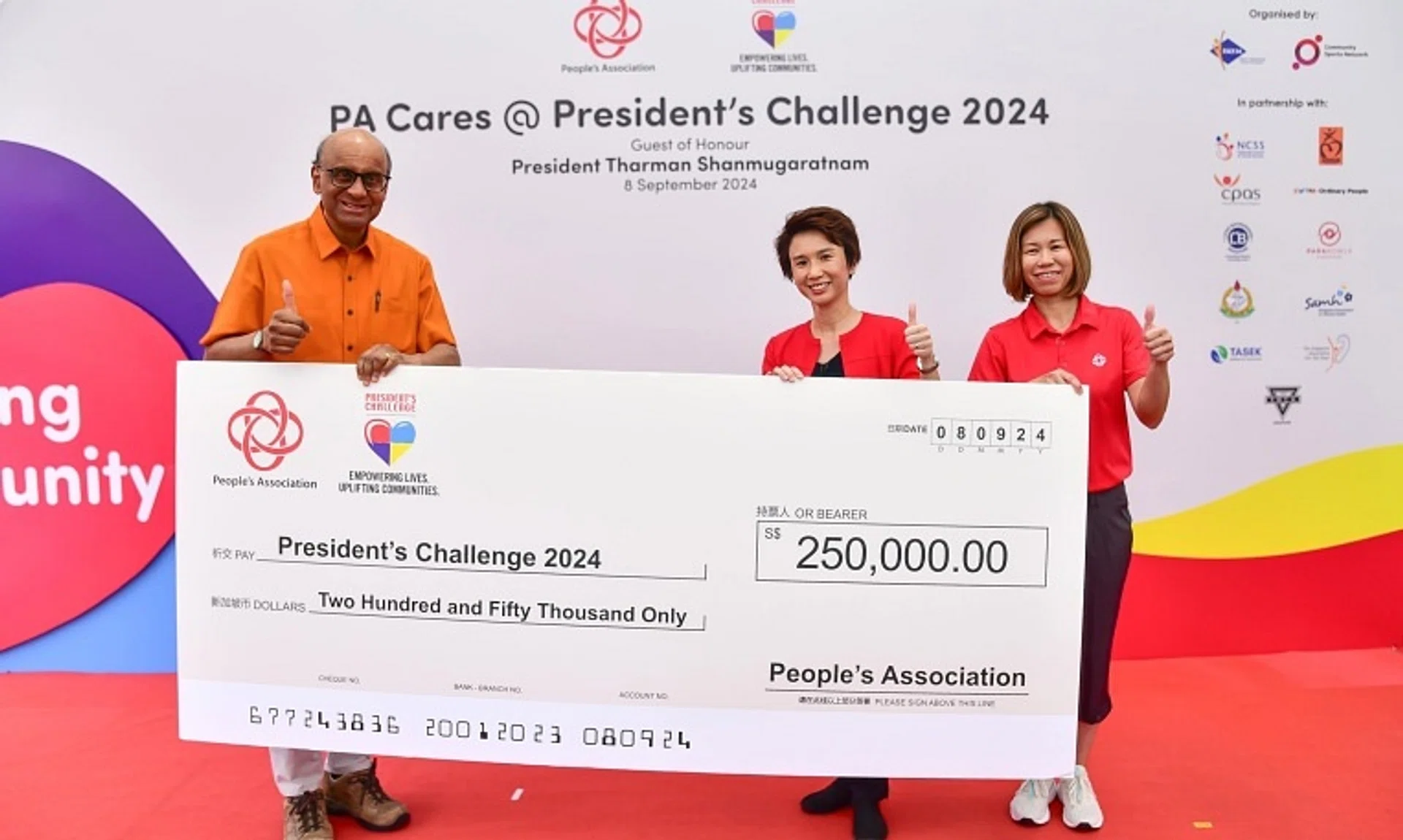 President Tharman Shanmugaratnam receiving a cheque of $250,000 from Ms Low Yen Ling (centre), Senior Minister of State for Culture, Community and Youth, and Trade and Industry, and People’s Association assistant chief executive Jeanie Tan.