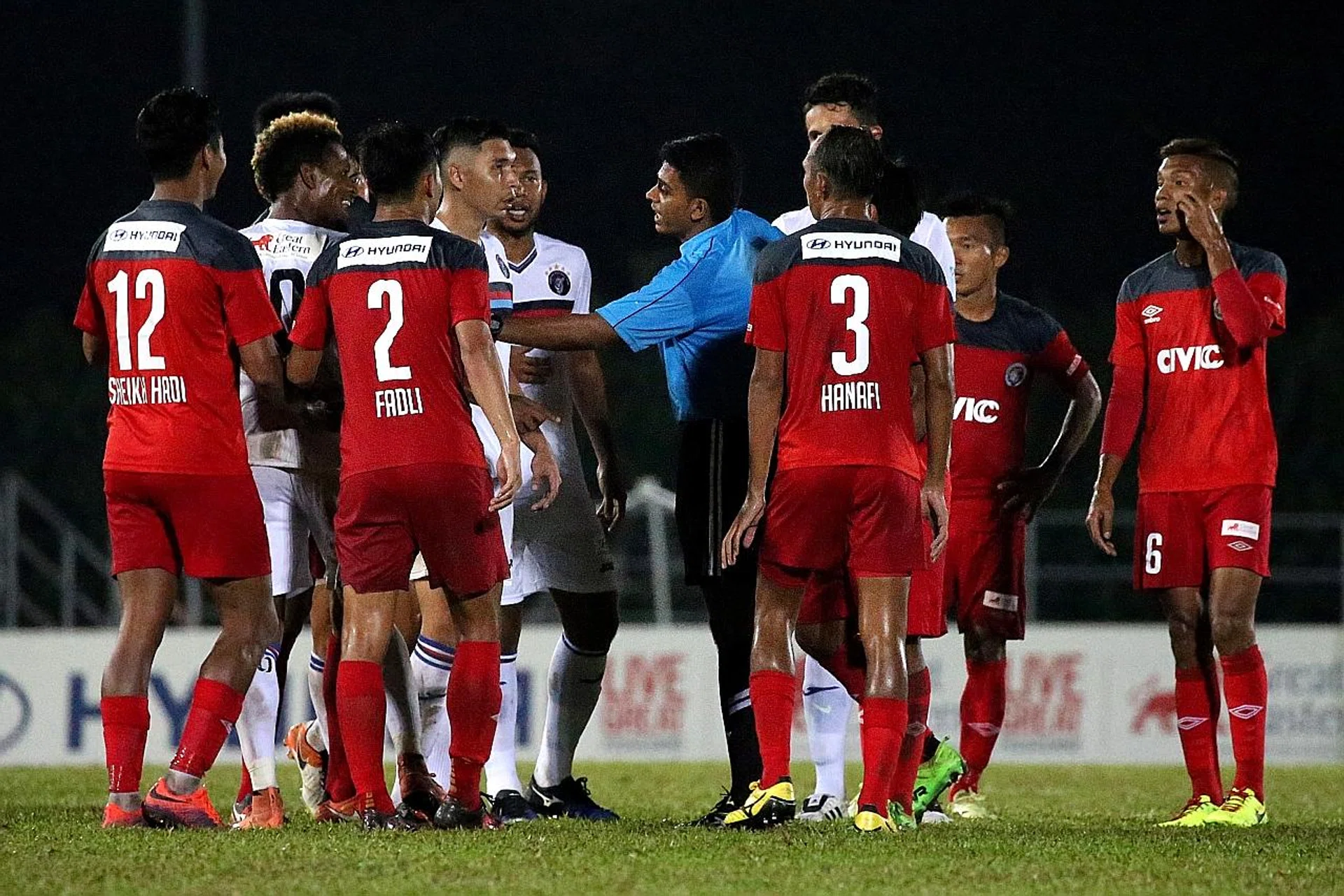 Referee G Letchman (in blue) stepping in as Warriors FC's Jordan Webb (second from left) and Balestier's Raihan Rahman (blocked by Hanafi Salleh, No. 3) clash .