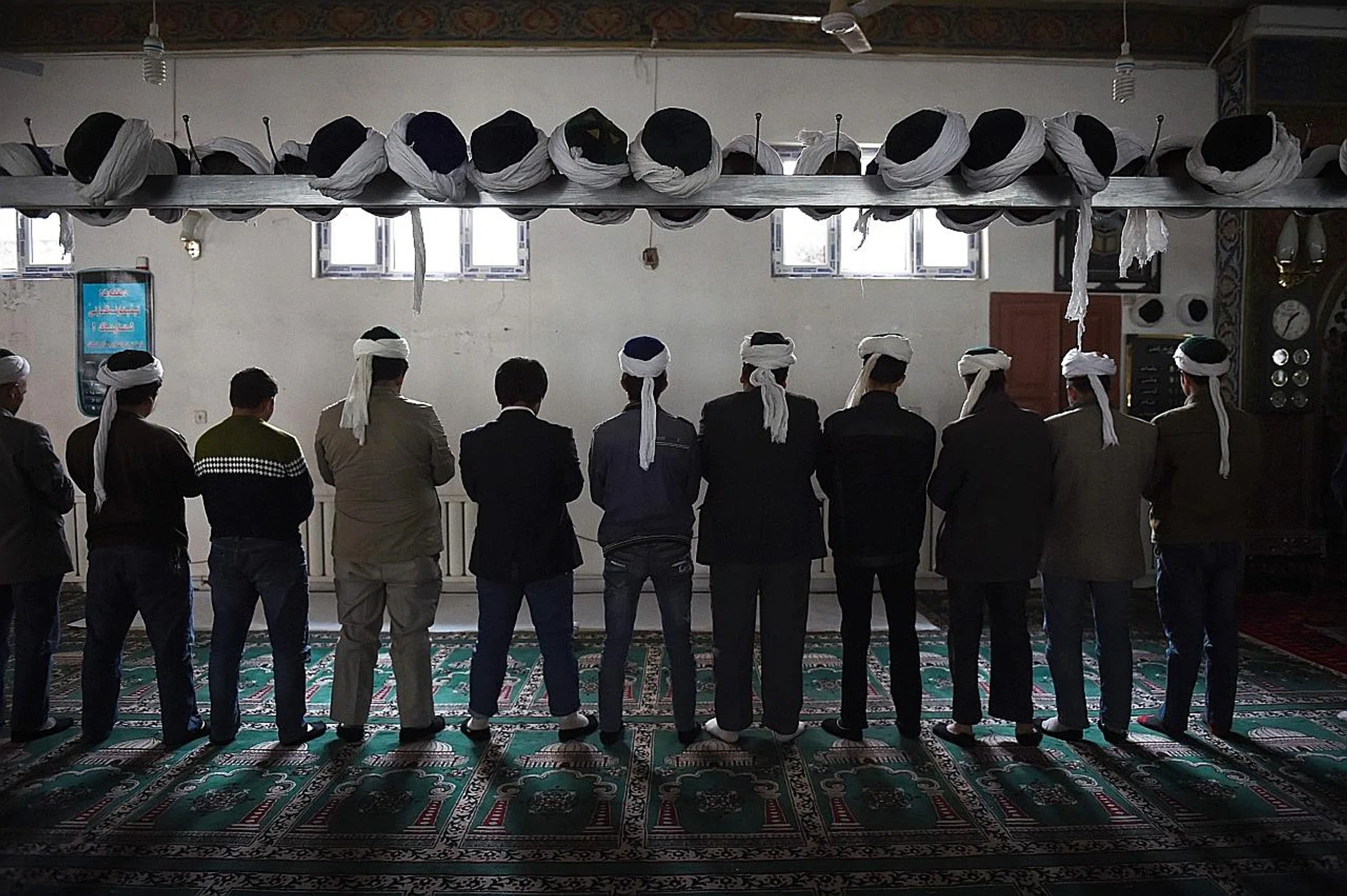 Uighur men praying in a mosque in Hotan, Xinjiang. The prefecture in the region's south has seen an explosion in number of "vocational training" centres for the region's Muslim minorities. 