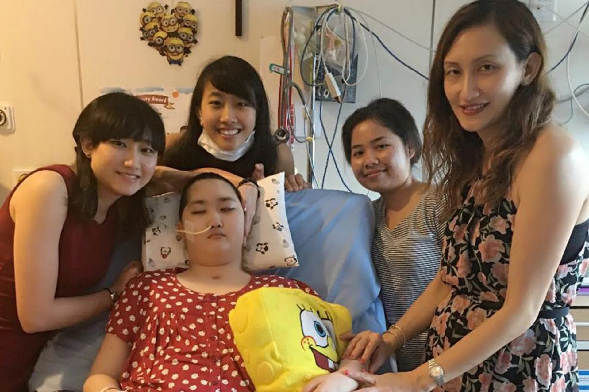 Ms Cecilia Ng (far right) with Jameen, her older daughters Jeannette and Janice (with mask) and her helper. 