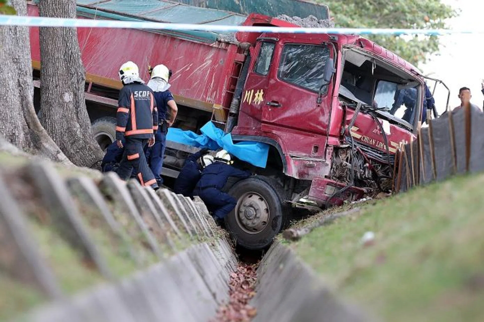 DEAD: Mr Zailee Othman was sitting by the roadside as his container truck had broken down when he was hit by a tipper truck, which ended in a ditch.