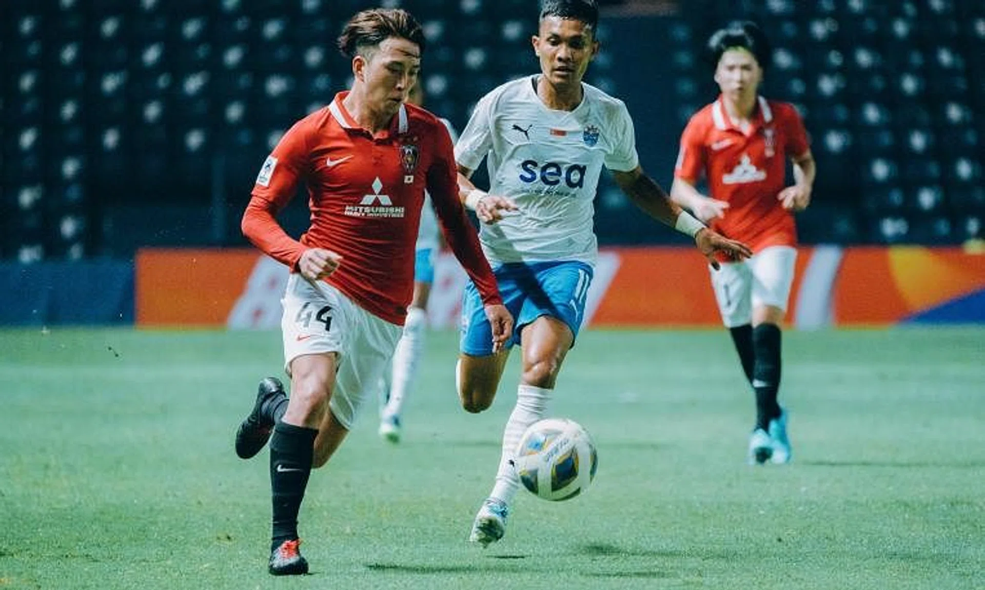 Urawa Red Diamonds' Ayumu Ohata dribbles away from Lion City Sailors winger Hafiz Nor.