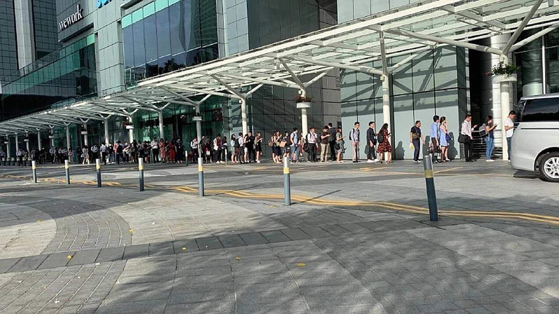 A long queue outside Tower 5 at Suntec City as workers wait for their turn to have their temperature taken. 