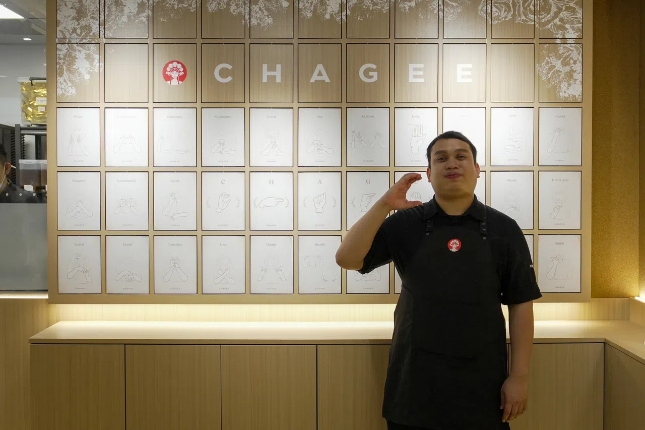 Mr Salahuddin standing in front of the flip chart, signing the letter C. PHOTO COURTESY OF CHAGEE