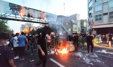 Iranian protesters set fire to police station after detained woman's death