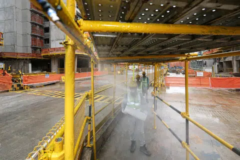 A covered walkway with a misting system runs through the Central Weave @ AMK construction site, helping workers to cool down before resuming work.