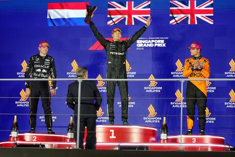 Race winner George Russell (centre) of Mercedes, second-placed Red Bull Racing driver Max Verstappen (left), and McLaren's Lando Norris after the 2025 Formula One Singapore Airlines Singapore Grand Prix.