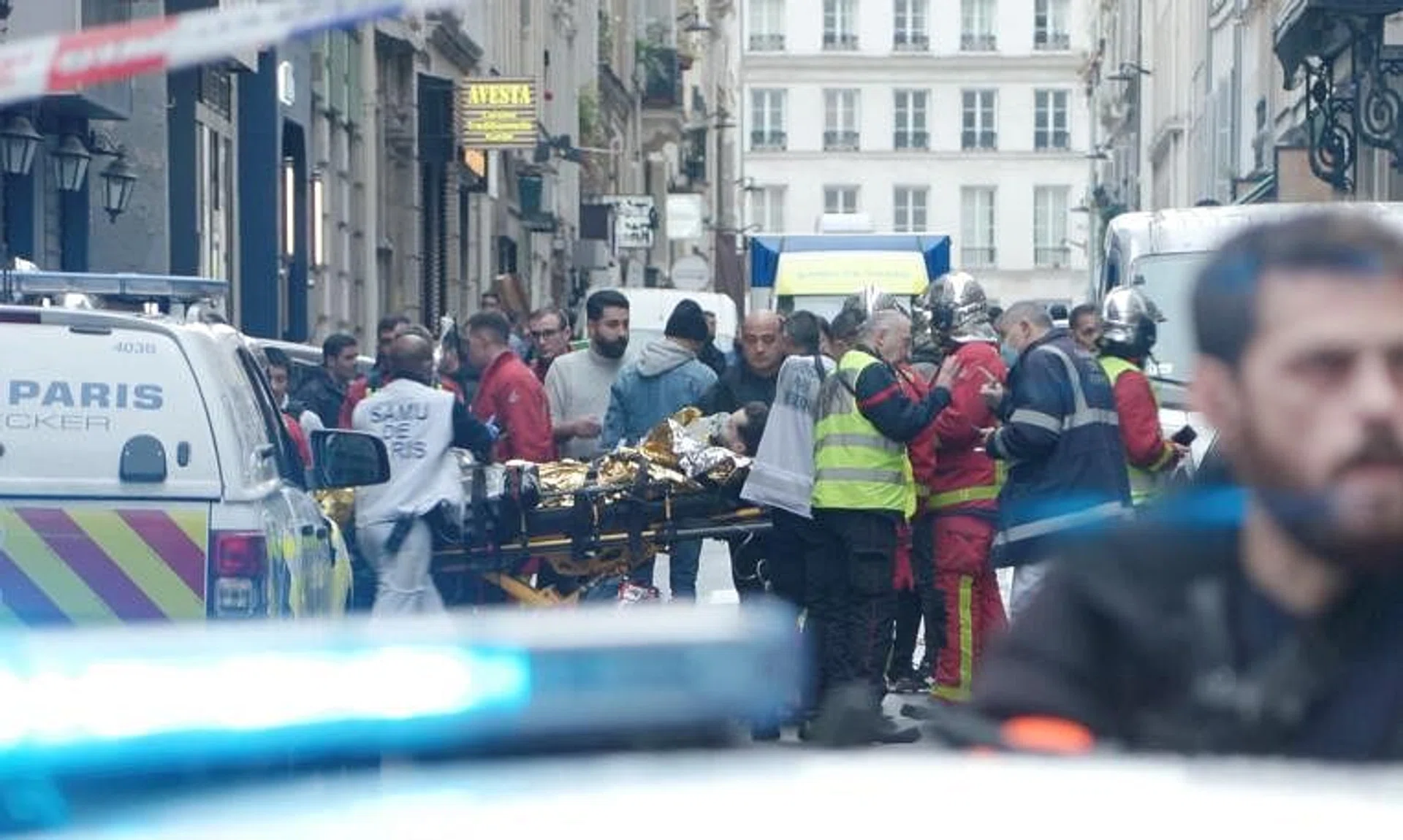 First responders move a man on a gurney after gunshots were fired in central Paris, France, on Dec 23, 2022.