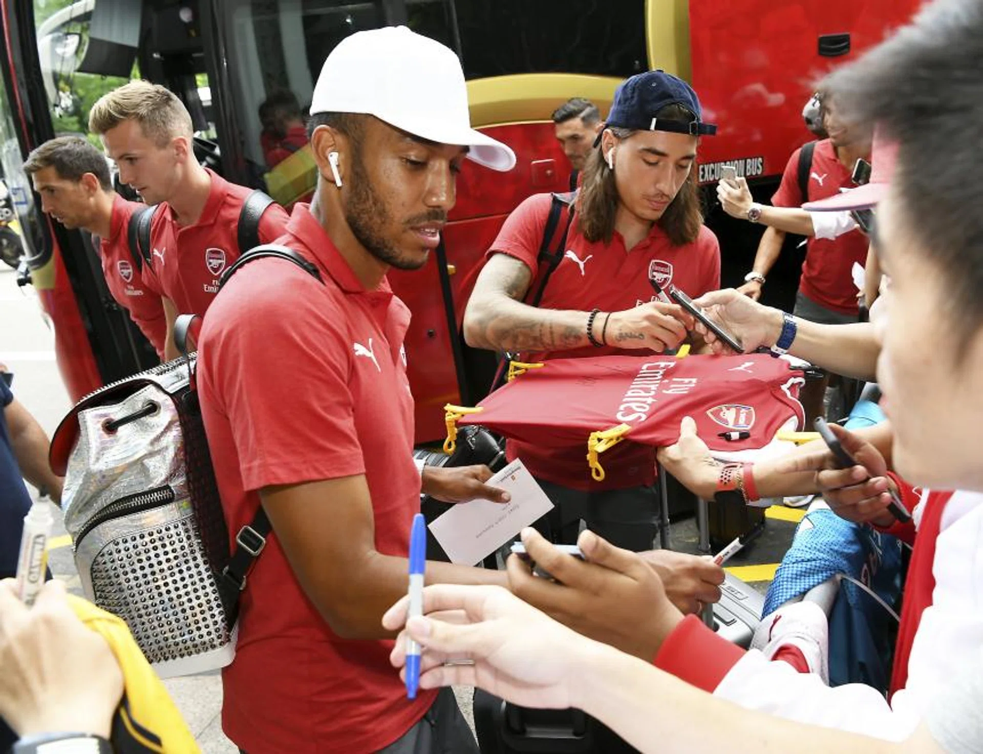 Pierre-Emerick Aubameyang (front) and Hector Bellerin (background) obliging autograph hunters after arriving at the Shangri-La Hotel on Monday morning. 