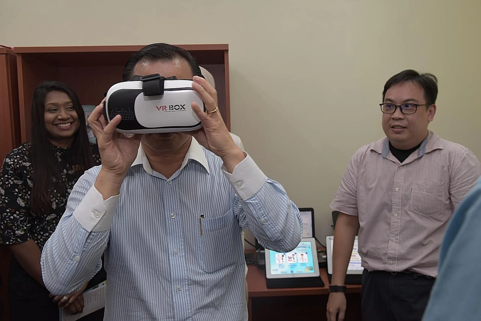 Guest of honour, Deputy Speaker of Parliament Seah Kian Peng, trying on the VR machine.