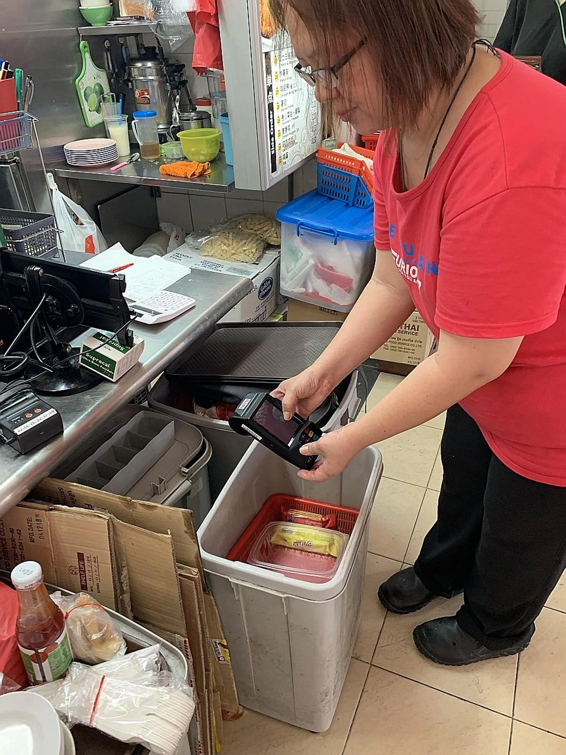 Ms Tham Mei Leng runs a Western food stall and feels more at ease now that e-payments will be processed the same day. 