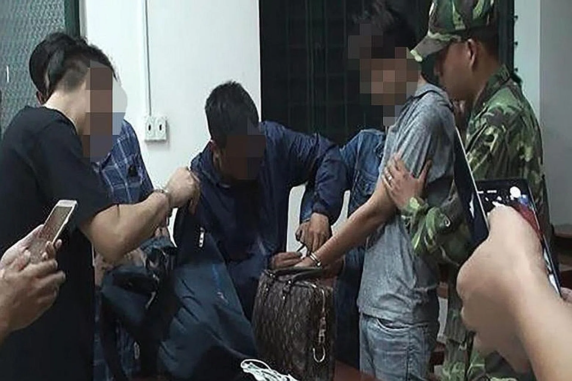 Vietnamese officials searching the belongings of the suspects. 