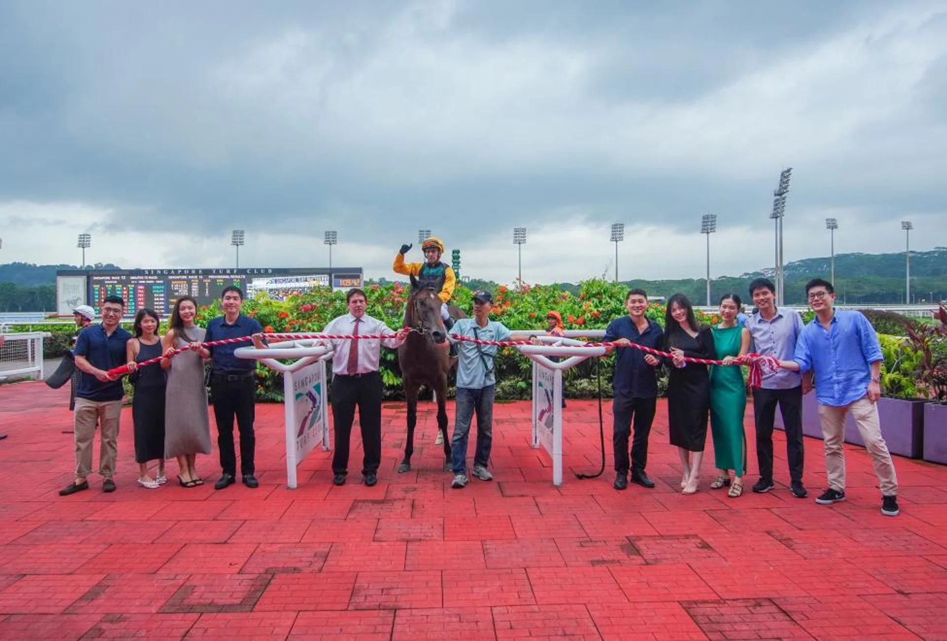 Singapore's ultimate 2023 winner Silo (Vlad Duric) is led in by the happy bunch of (from near right) Calvin Yeap and wife Elvinita, Woo Aichia and husband Melvin Tjahaja (owner), trainer Stephen Crutchley, syce Khairull Johari, Ian Ong (owner), Charmaine Hanng, Fiona Lim and husband Kenneth Chng (owner) and Yang Xin Yu.