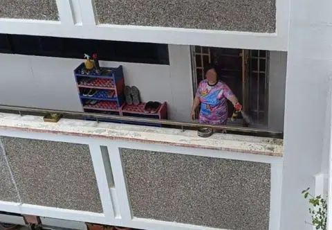 Woman lights mosquito coils, sprays insecticide daily