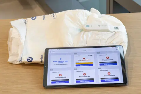 Monit's monitoring sensor is attached to the outside of the diaper using an adhesive.