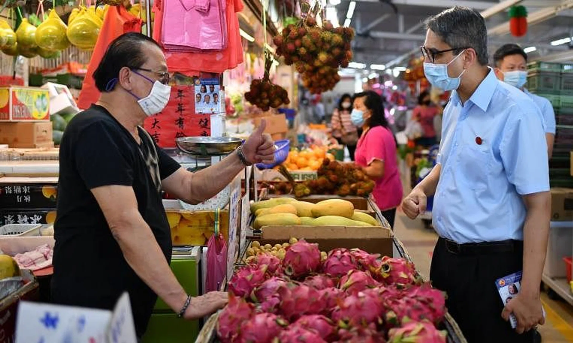 Mr Leon Perera (right), then a candidate for Aljunied GRC, during a walkabout at Kovan Market on July 2, 2020. 