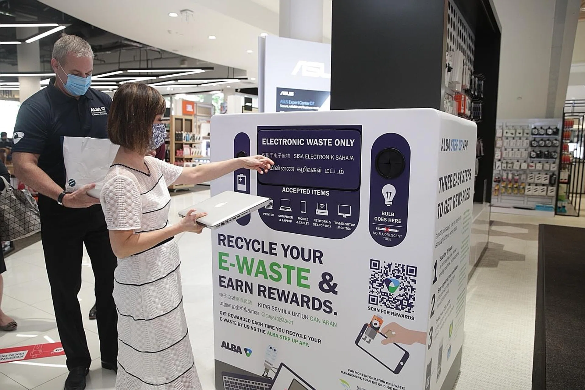 Senior Minister of State for Sustainability and the Environment Amy Khor depositing an item into an e-waste recycling bin. 