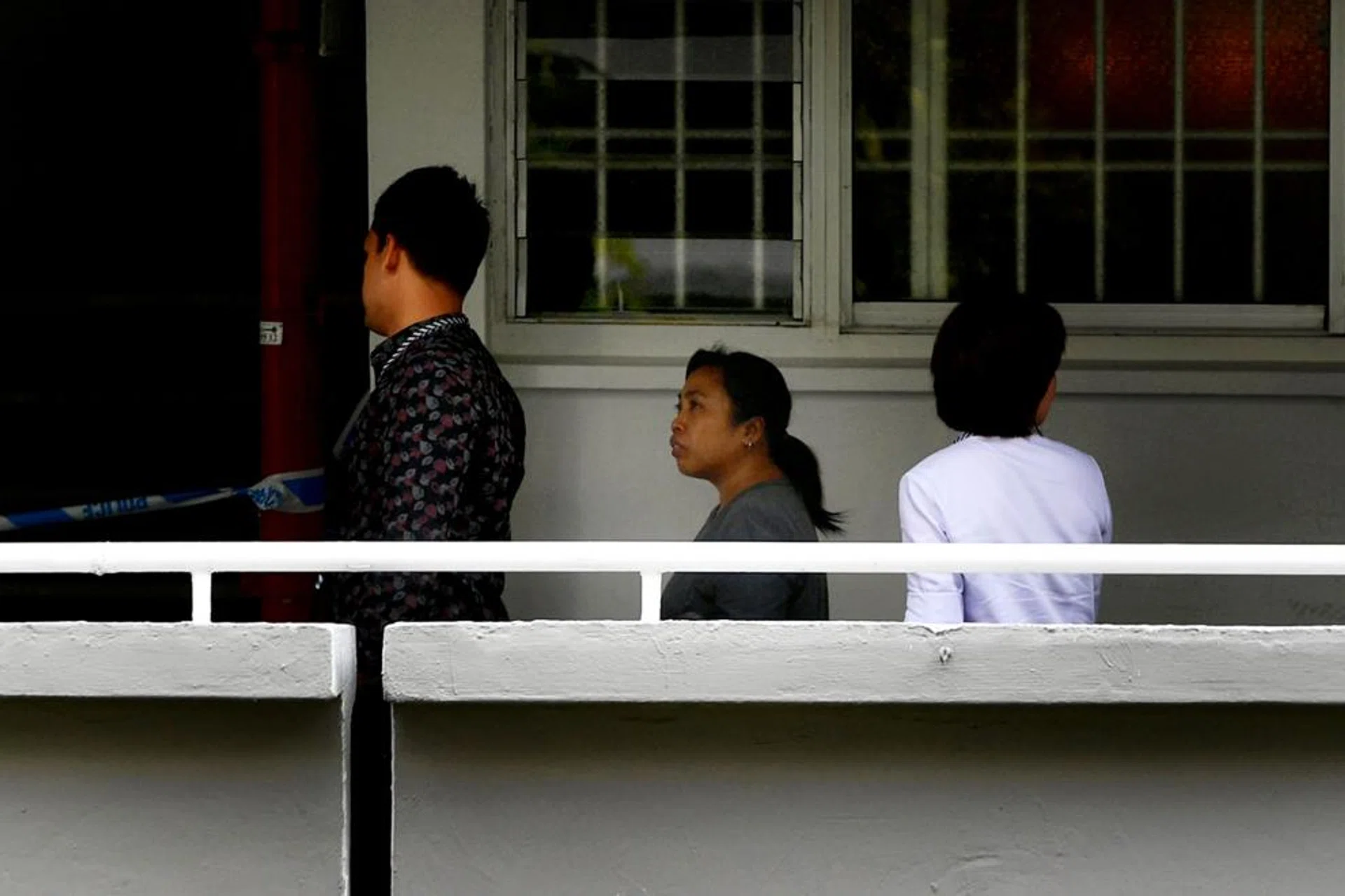 Police accompany the Indonesian maid (centre).  