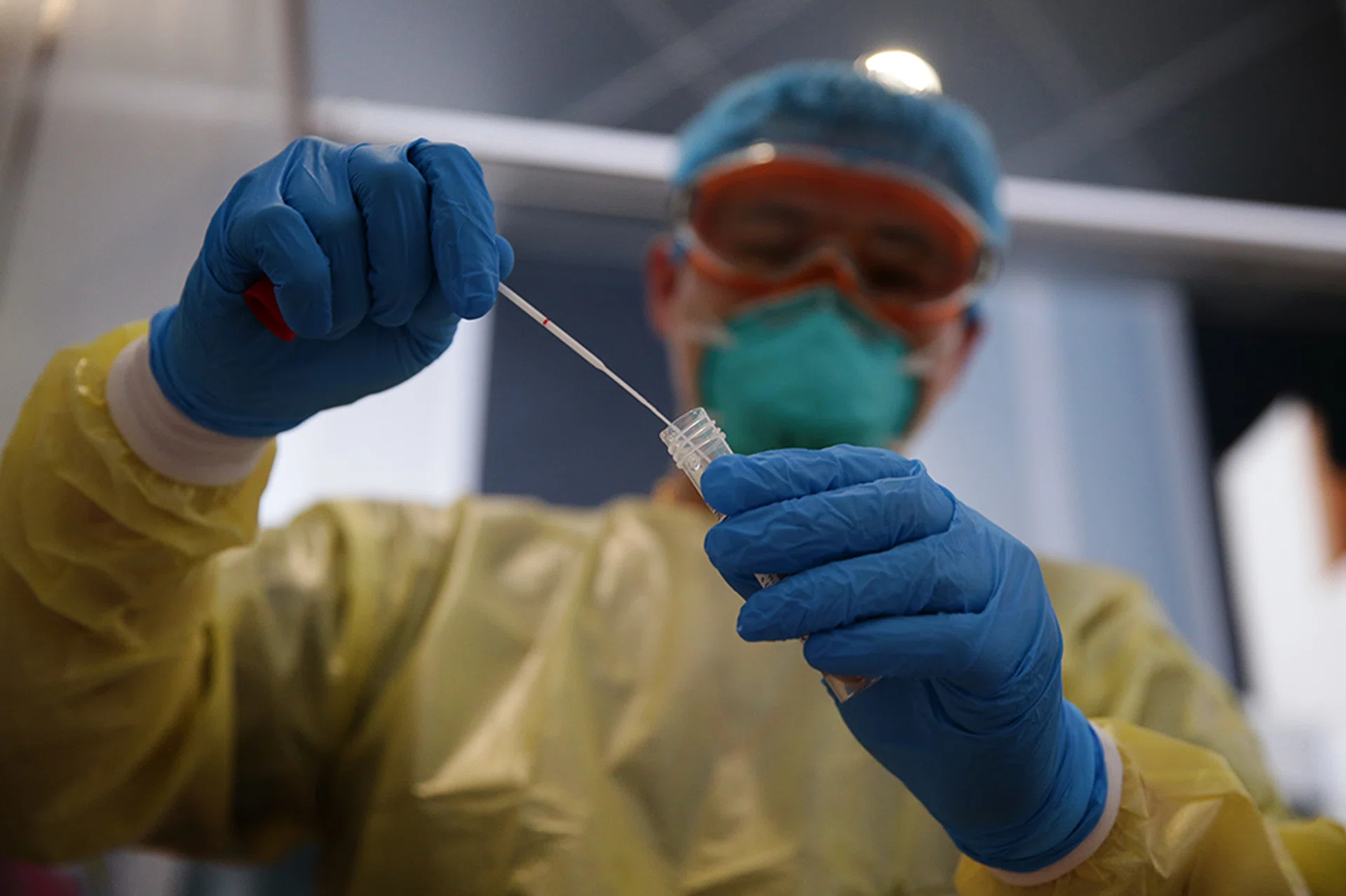 A healthcare worker storing a nasopharyngeal swab to test for Covid-19 