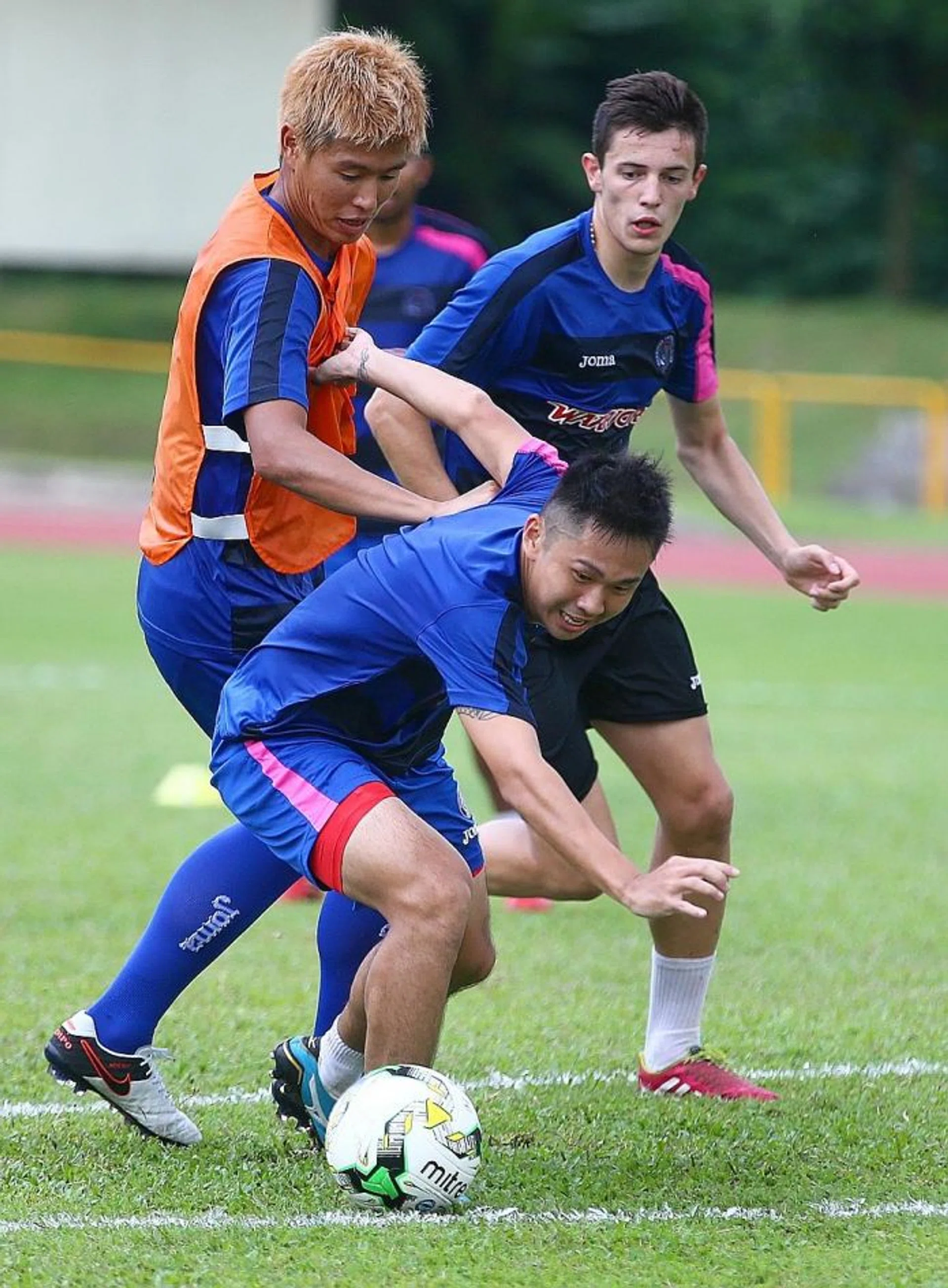 PUMPED UP: Warriors' Poh Yi Feng (in front) holding off Kento Fukuda (in bib) during a training session, as they prepare to fight for their 10th S.League title, when the season gets underway.