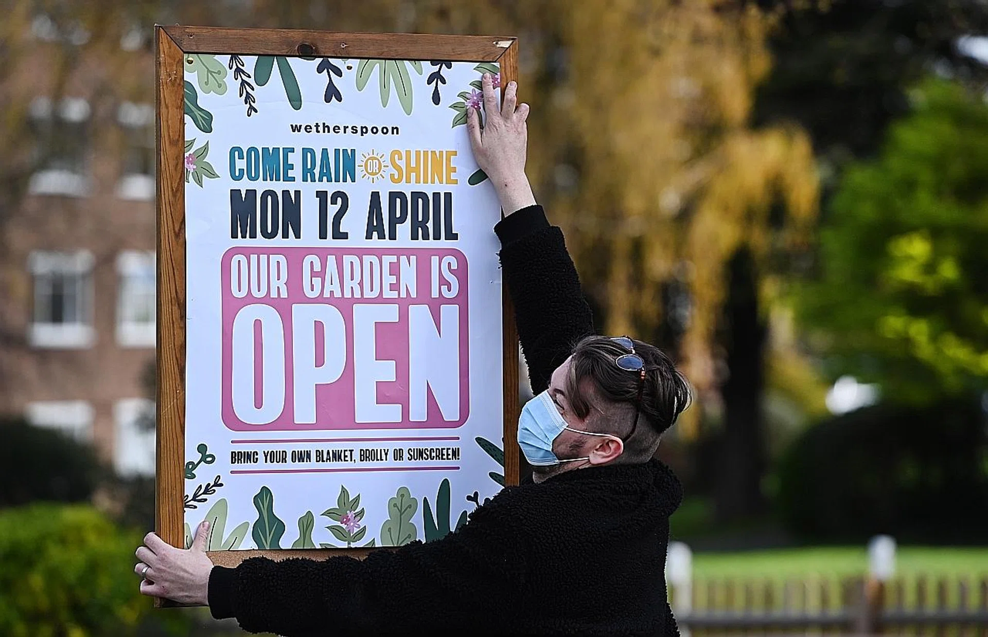 A pub staff pinning up a reopening sign in London yesterday. The UK is set to begin its second phase of easing restrictions after months of lockdown. PHOTO: EPA