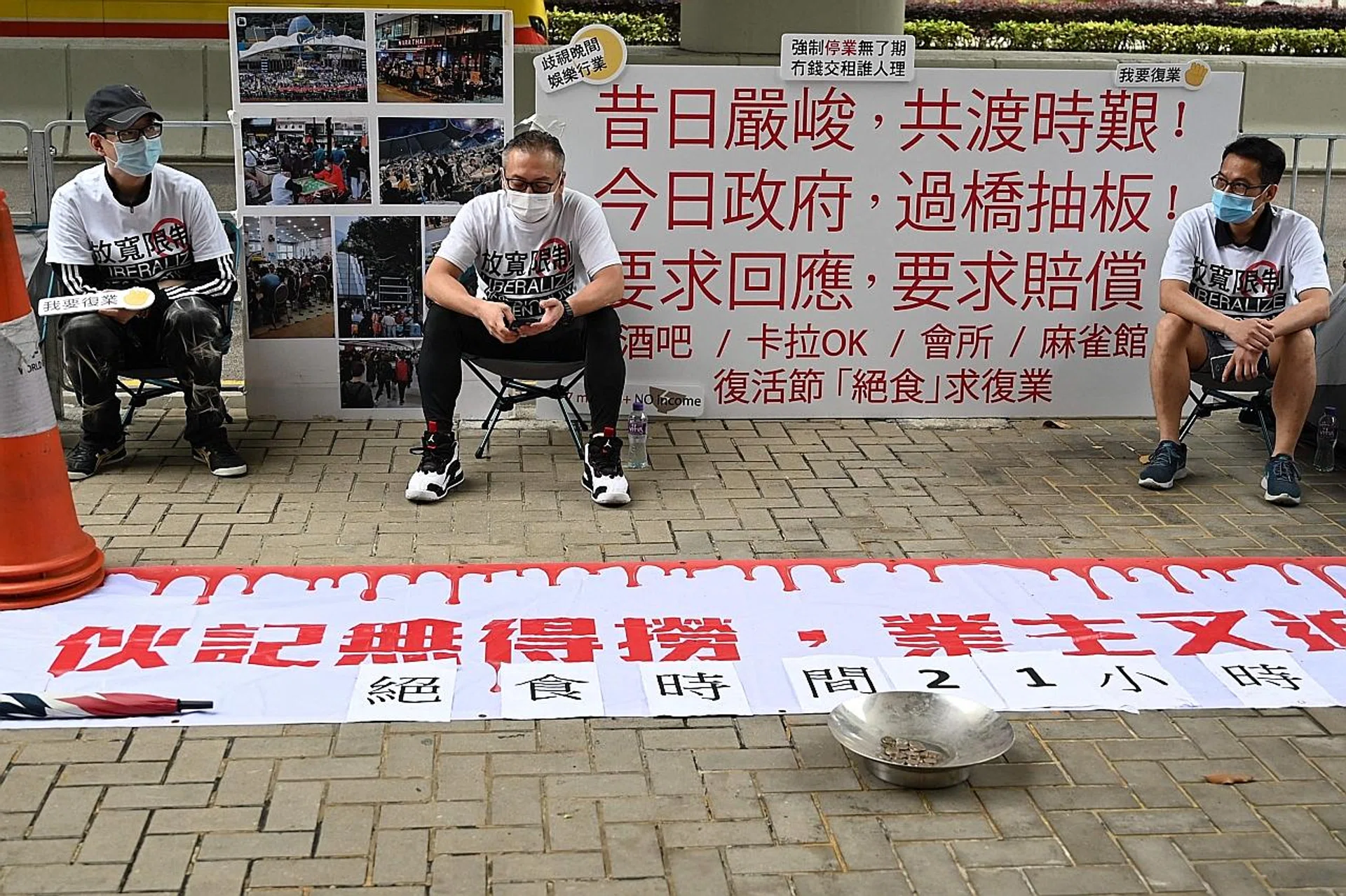 Members of a group representing bar, karaoke and mahjong parlour owners taking part in a protest outside the Hong Kong government's headquarters. 