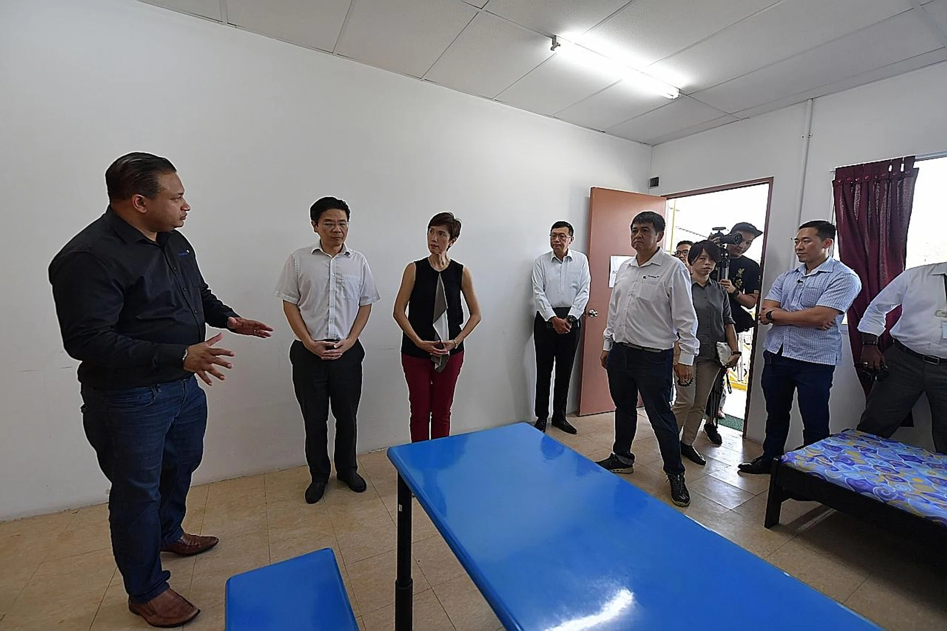 Minister of National Development Lawrence Wong and Minister of Manpower Josephine Teo (second and third from left) at Tuas View Dormitory, inside a 32-bed facility for workers who will serve a leave of absence upon returning from China. 