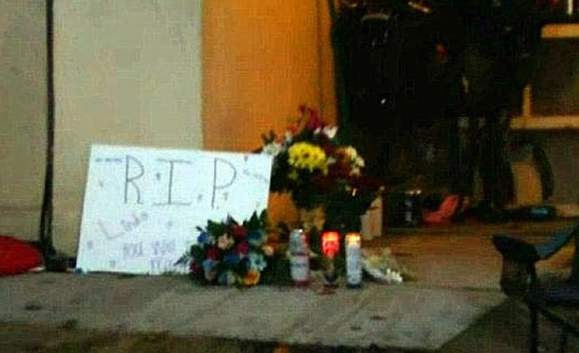 SHOOTING: (Above) Candles and flowers left at the door.