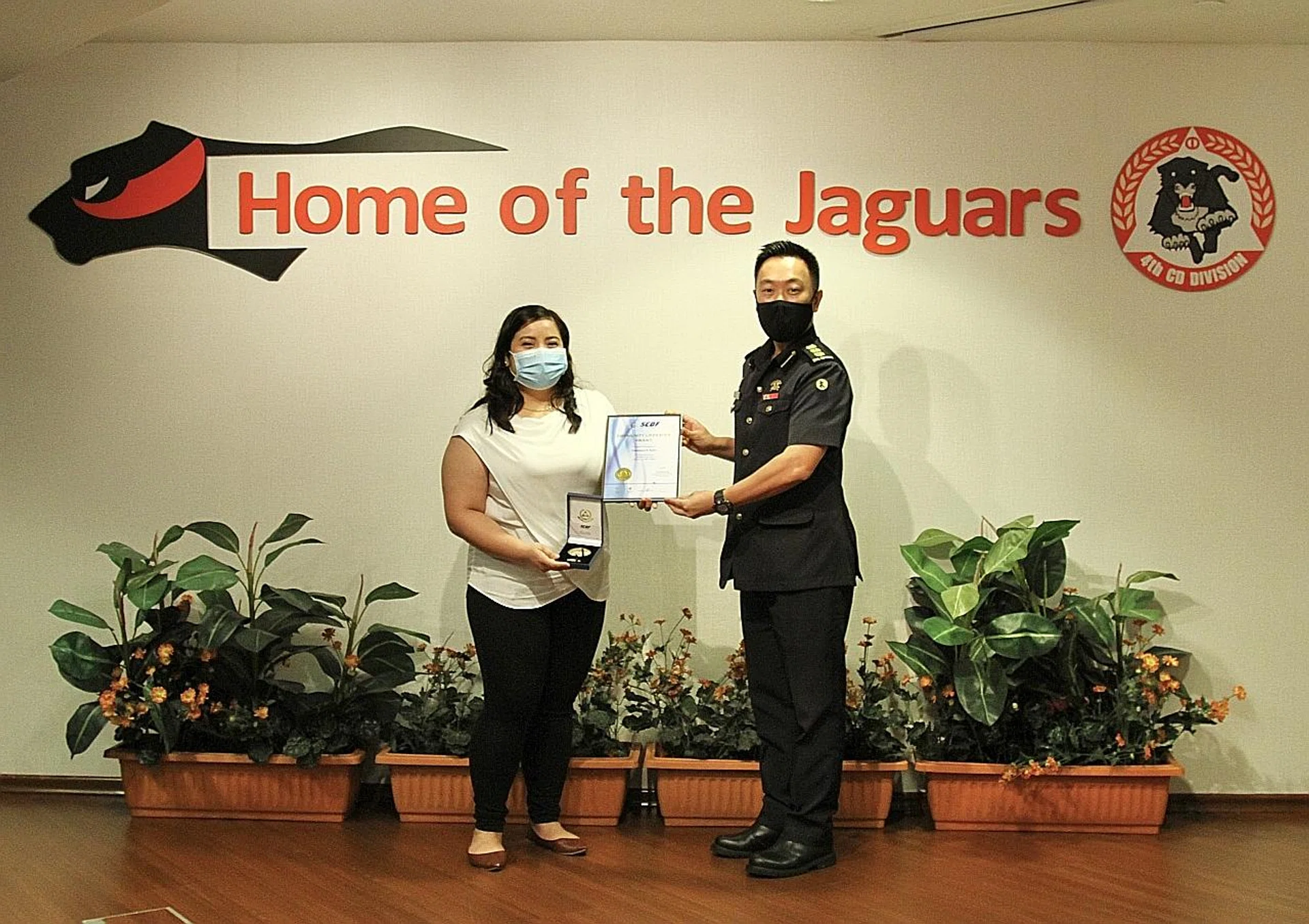 Ms Rubio Franchesca Santos receiving the Singapore Civil Defence Force's Community Lifesaver Award from Colonel Anthony Toh. 