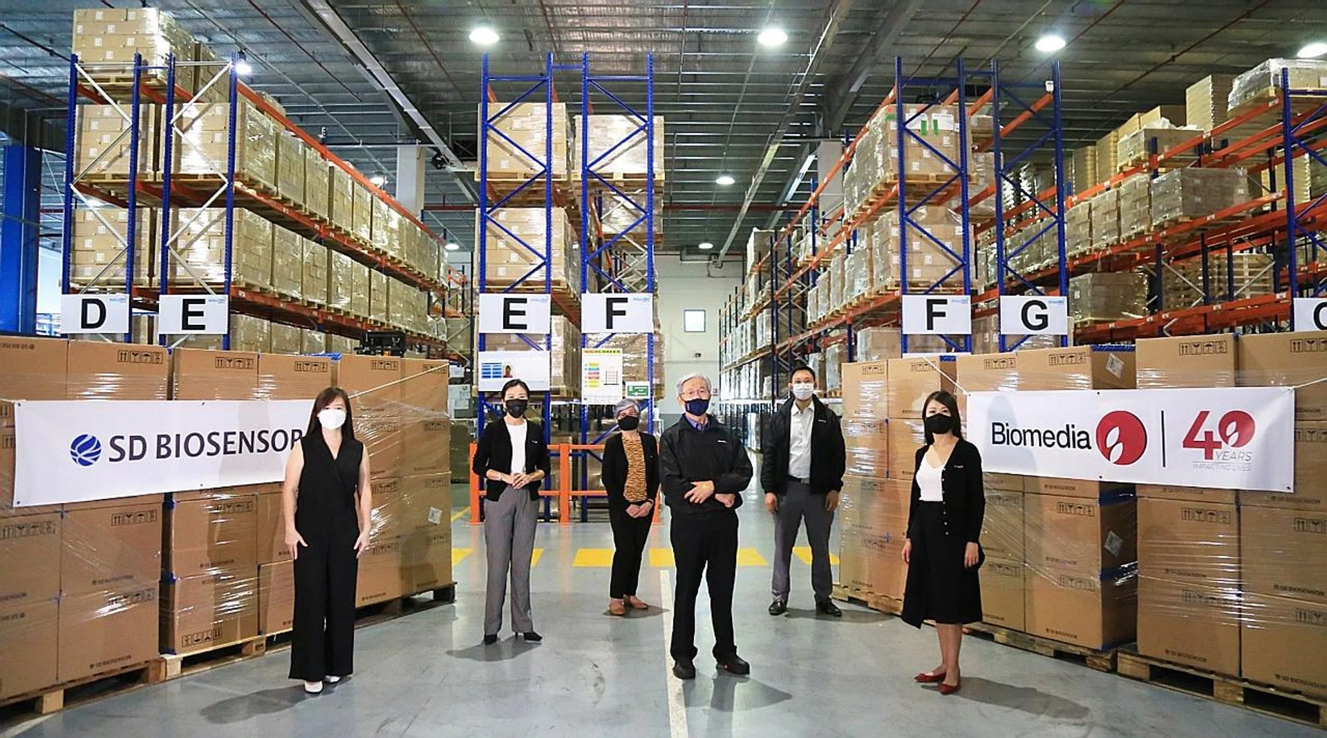 Ms Jes Lim (left), managing director of SPD Scientific, beside the company's stock of SD Biosensor test kits. She said the firm's warehouses can hold some 20 million kits at a time. 