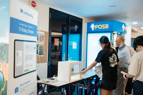 The LetterKey team helping a senior scan a letter at the physical kiosk in Bukit Panjang Community Club in July. 