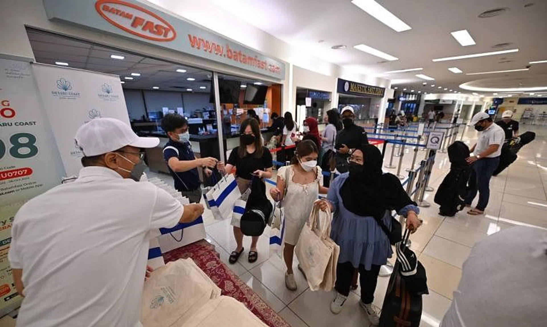 Passengers collecting their goodie bags from MPA and Desaru Coast at Tanah Merah Ferry Terminal on July 7, 2022.