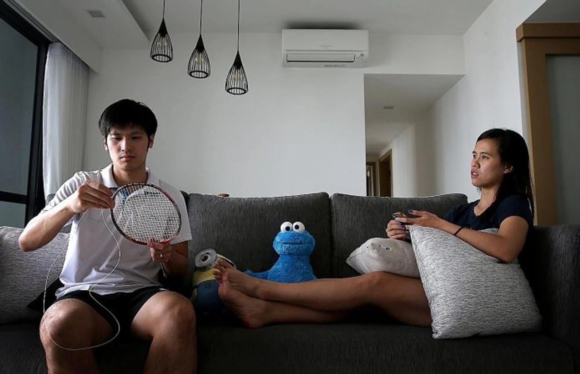 PULLING THE STRINGS: (Above) National badminton player Derek Wong stringing rackets at home with his wife Vanessa Neo, also a national shuttler.