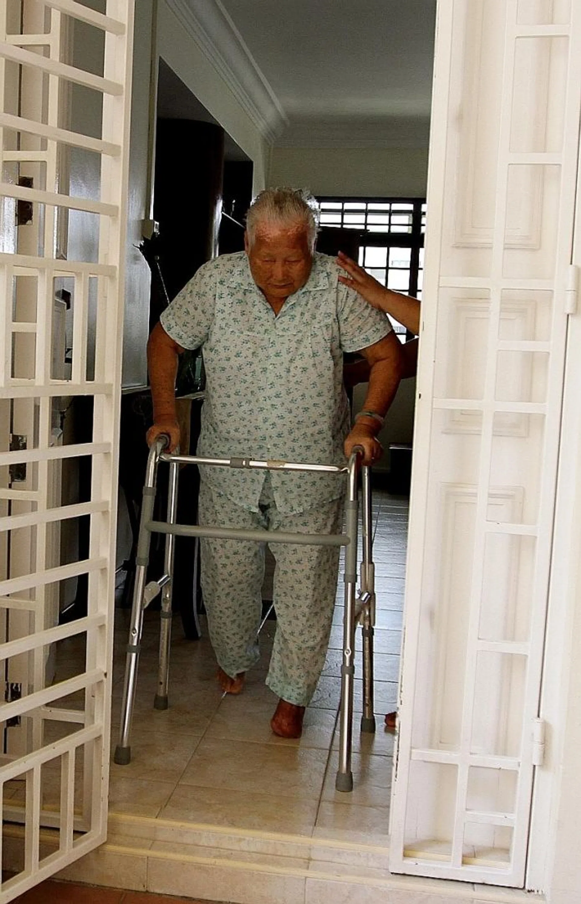 LIFE CHANGED: She now uses a walker to get around in her flat in Tampines.